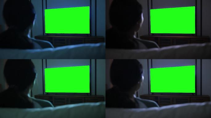 用绿色屏幕看电视的女人