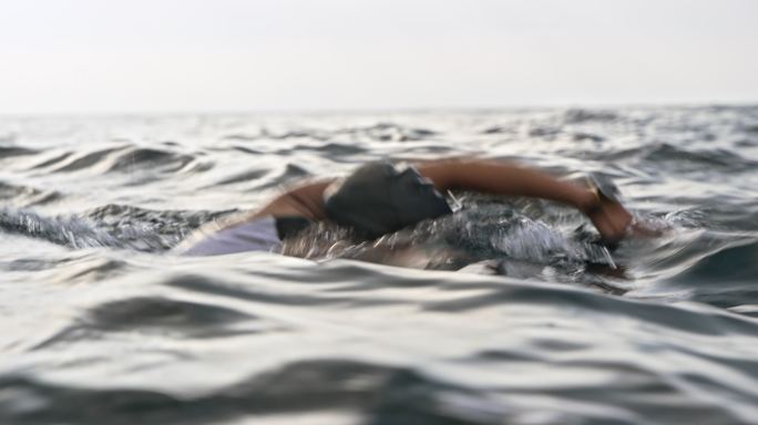 TS女子游泳运动员在海中向前爬行