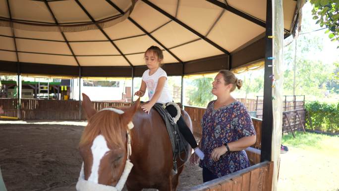 患有自闭症的女孩在一家私人中心接受马匹治疗。