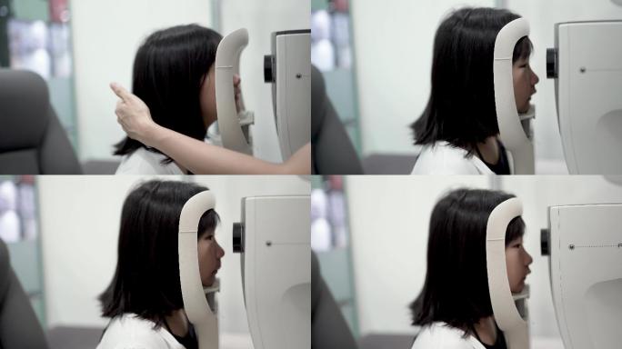 中国亚裔女孩在眼科诊所坐在椅子上用数码验光仪进行眼科检查