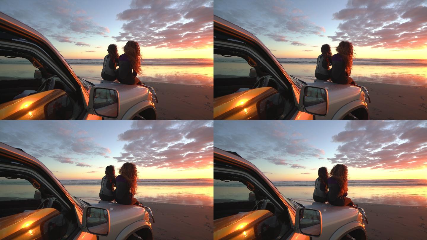两个朋友在海滩上欣赏日落。