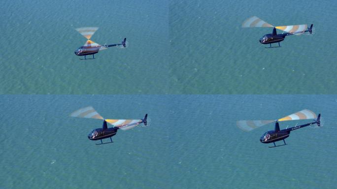 空中直升机在阳光下飞越海面