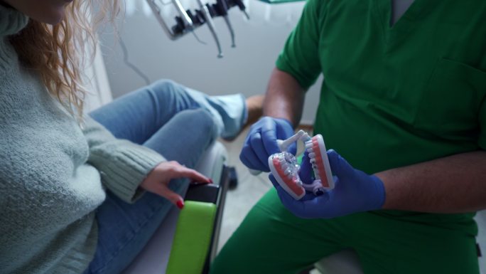 男牙医向女患者展示如何正确刷牙