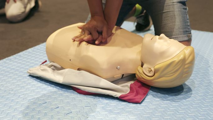 心肺复苏培训班展示了在假人上抽水、急救或医疗保健概念。
