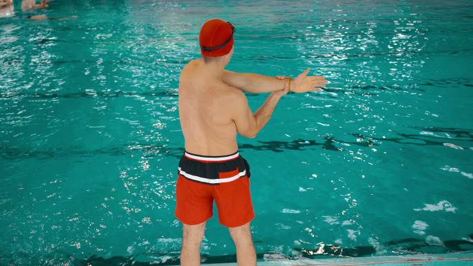 年轻男子在游泳池训练前伸展身体