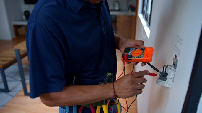 电工固定电源插座并测量房屋电压的特写镜头