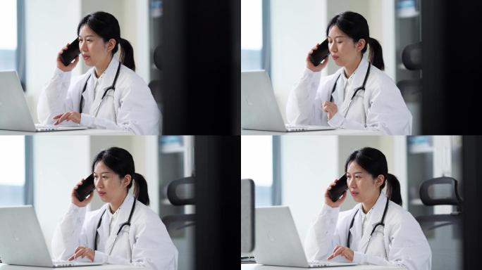 年轻女医生在办公室使用笔记本和手机工作