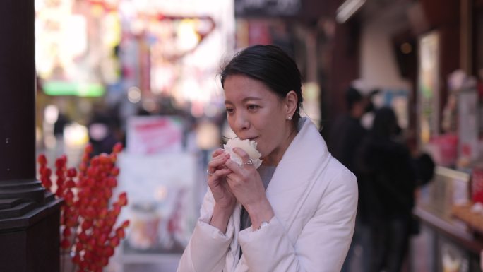 下班后在唐人街吃猪肉包子的年轻女子
