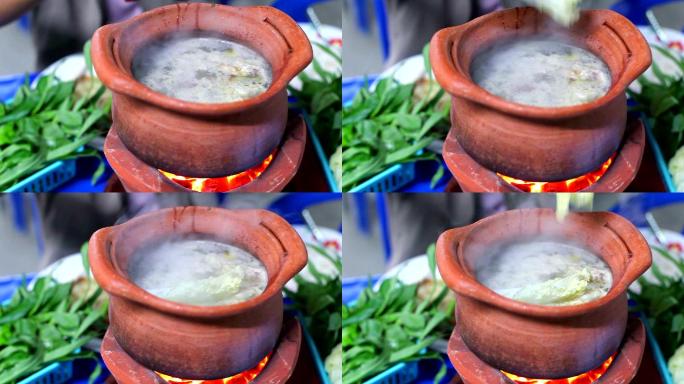 女孩在泥锅里填蔬菜做泰国火锅街头食物（JimJum）