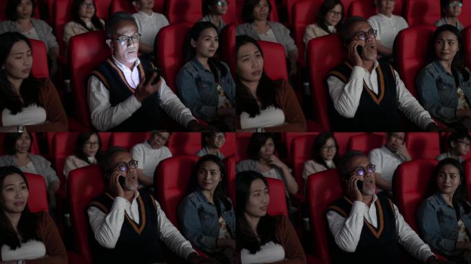 电影在电影院放映时，亚裔中国老人正在使用智能手机。打扰她周围的其他观众