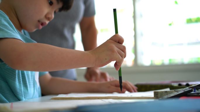 亚洲资深女子在家教孙子中国传统书法