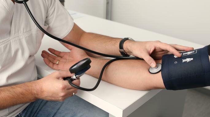 医生测量男性病人的血压