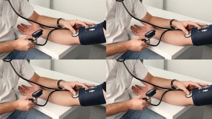 医生测量男性病人的血压