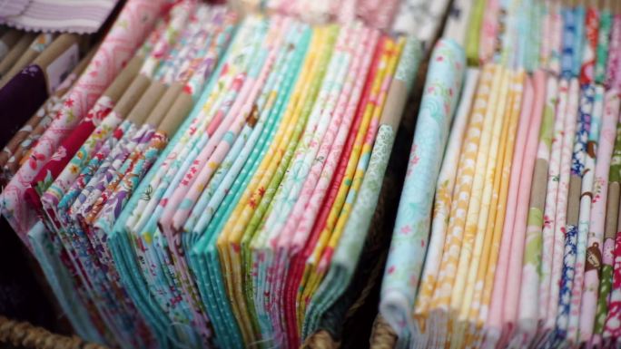 一堆彩色织物，印有花卉图案的床单，手工制作和手工艺品概念。
