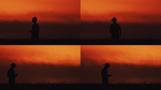 戴着太阳帽的斯洛莫农民站在橙色天空下的麦田里
