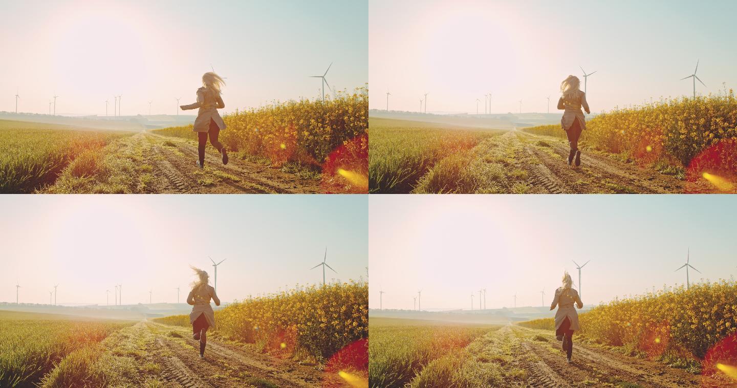 超级慢-时间扭曲效应女子在油菜田上奔跑，远处有风力涡轮机