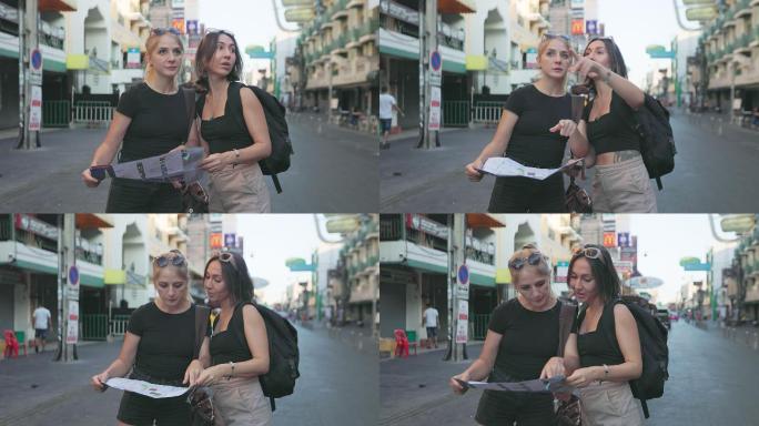 两名年轻的白人高加索女游客在曼谷探索时使用地图进行讨论。