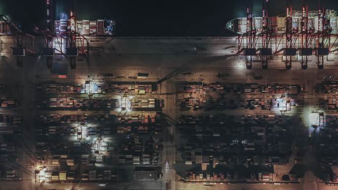 夜间繁忙工业港口集装箱船的T/L PAN鸟瞰图