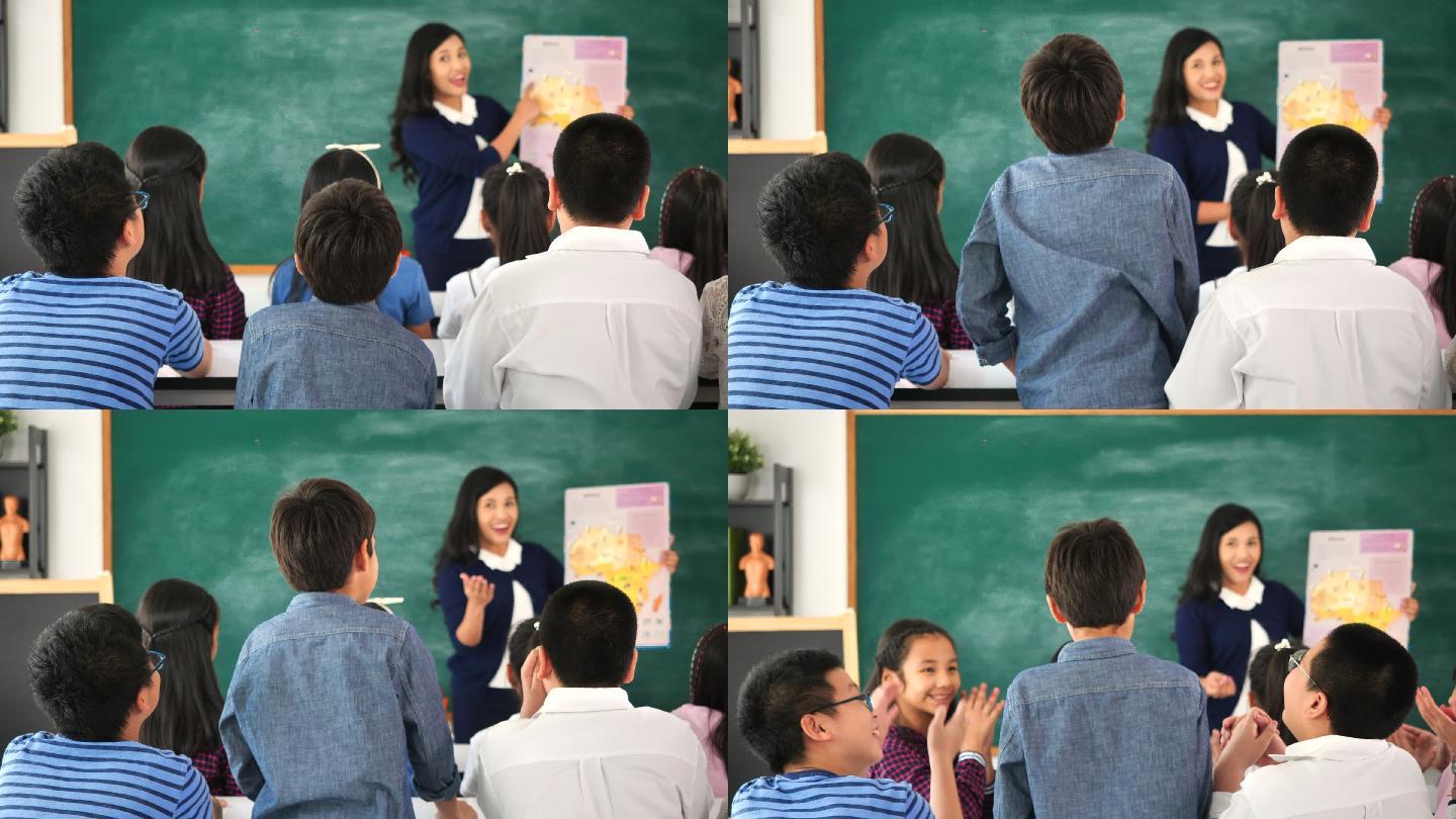 演讲期间，男生站在课堂上举手回答问题的后视图。学生举手向讲师提问。
