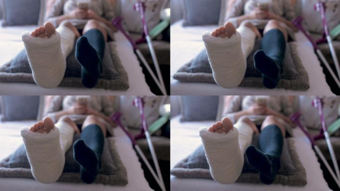 残疾女子在家使用智能手机时摔断了腿和石膏脚