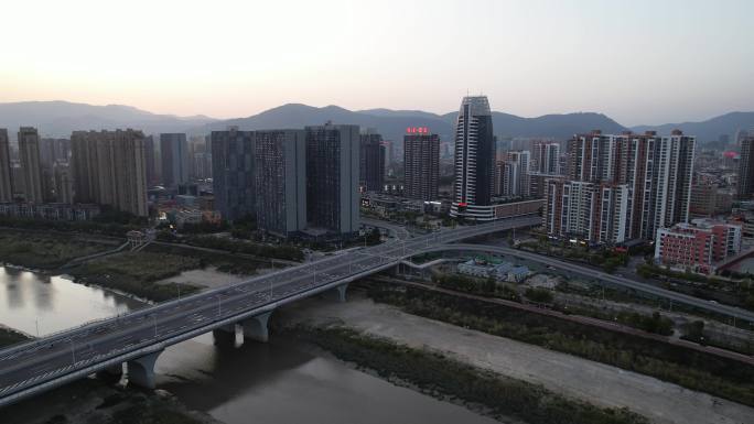 黄昏时连接城市的桥梁的无人机透视图