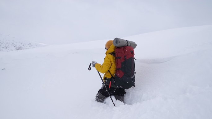 冬天背着背包在山上徒步旅行的男人