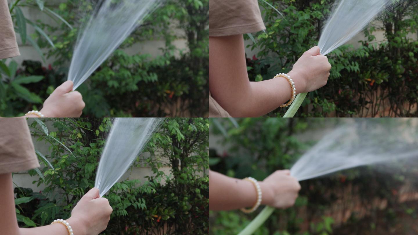 4K，女孩手持式浇水软管和花园浇水树