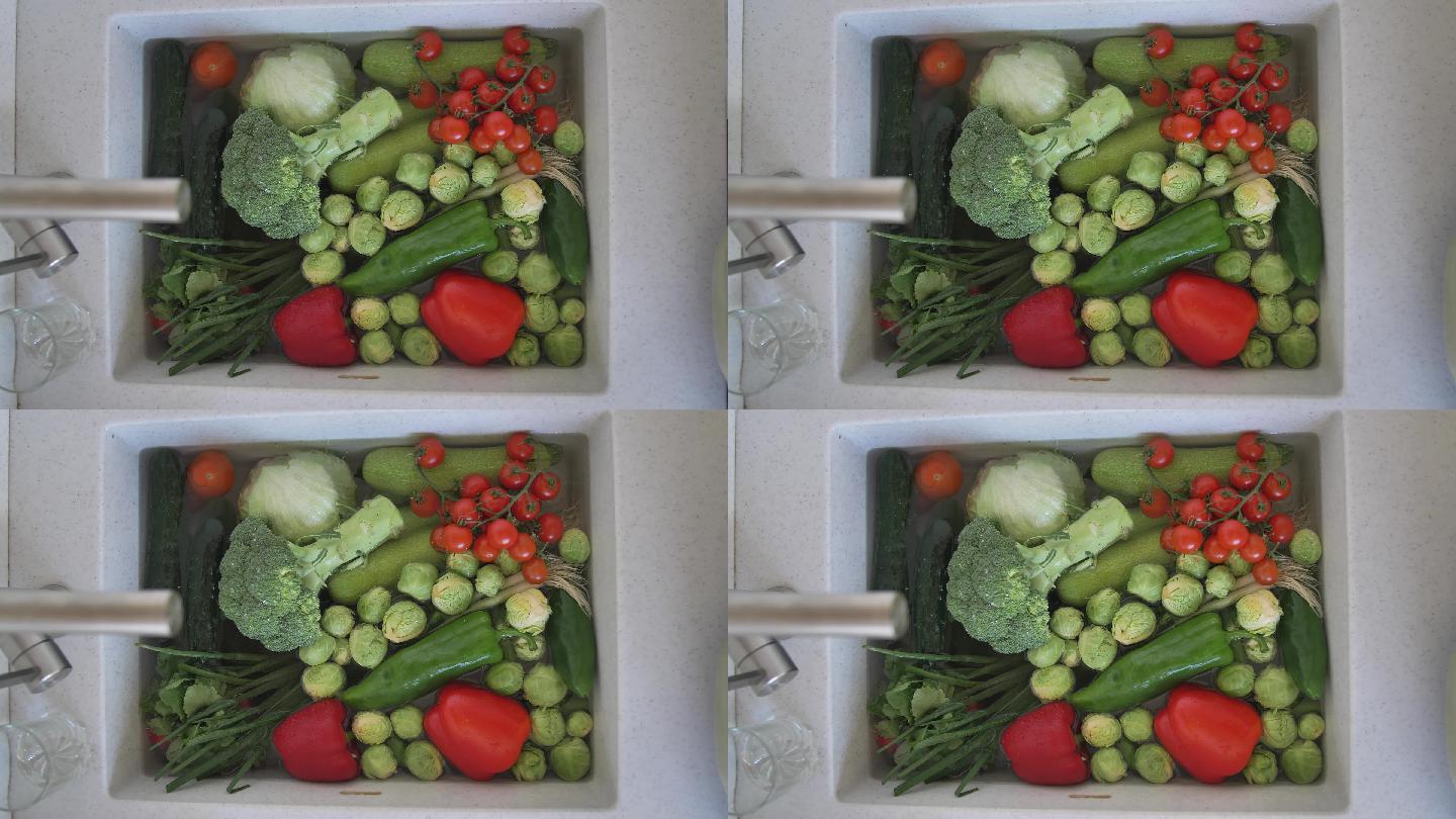 厨房水槽里装满了浸泡在水中的新鲜蔬菜