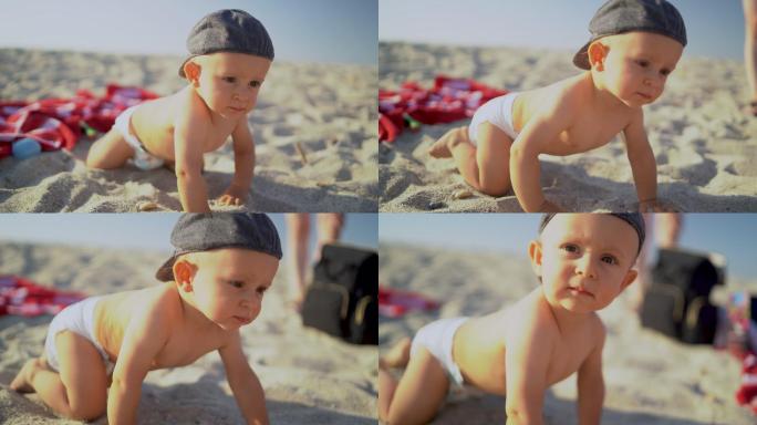 坐在海滩上的男婴爬行