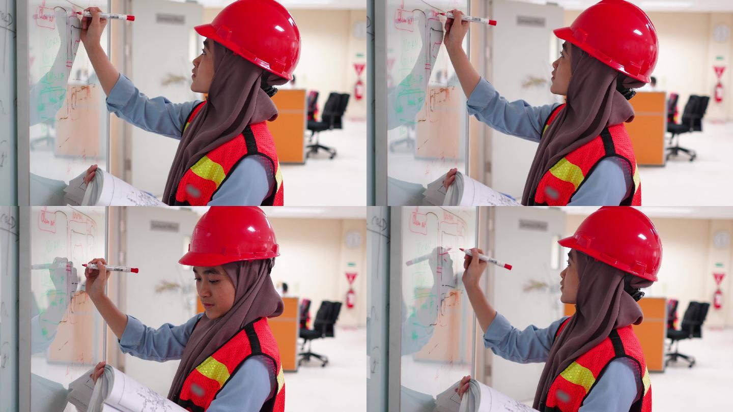 工程师穆斯林女性在办公室的白板上开发设计和书写