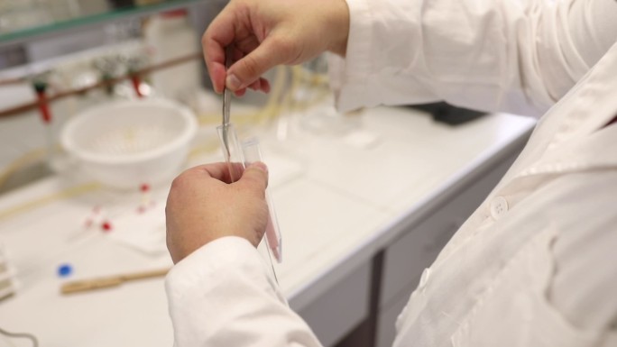法医学在法医实验室分析纤维样品，同时进行石蕊测试