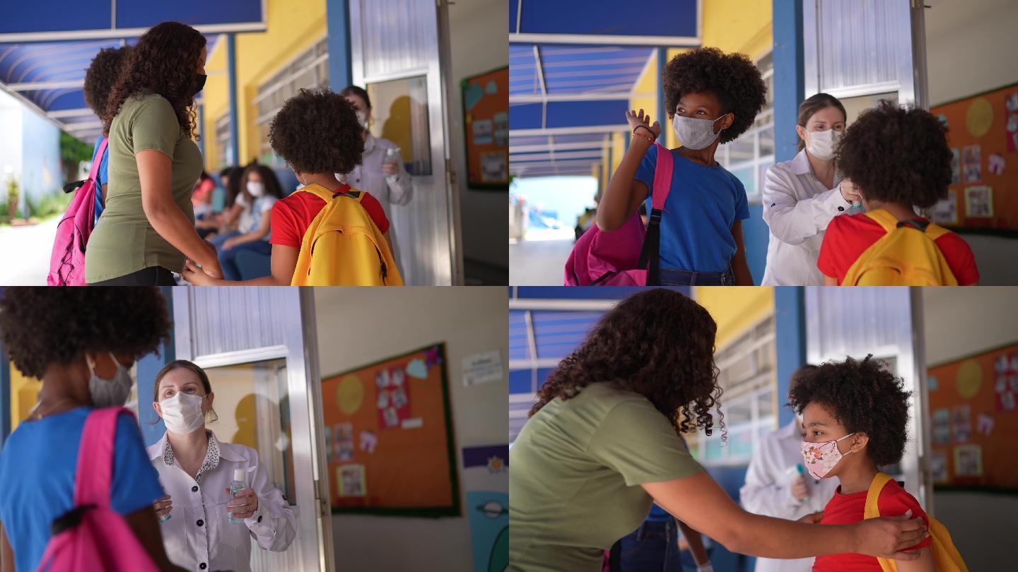 老师在进入学校前测量学生的体温并在其手上涂抹洗手液-使用面罩