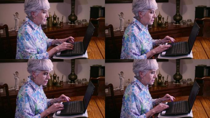 一位拉丁美洲资深女士坐在餐桌旁，在家里用笔记本电脑工作