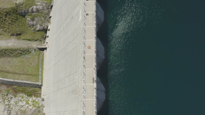 在晴朗的日子里，空中无人机拍摄到深蓝海水的大坝