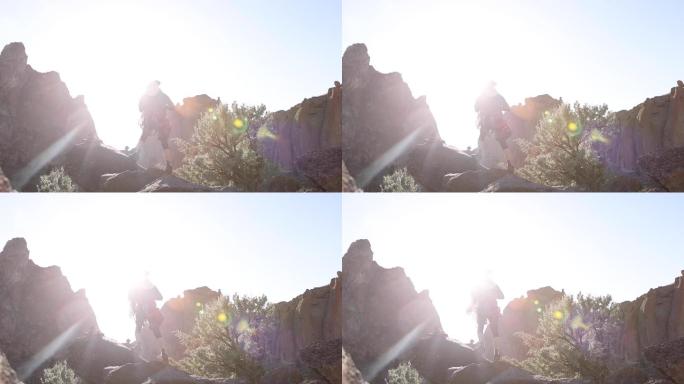 史密斯岩站在太阳耀斑前的岩石上的登山者