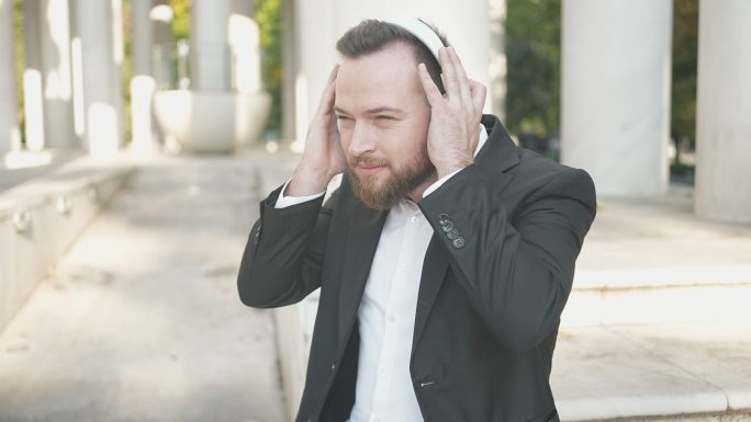 优雅的男性在数字平板电脑上欣赏音乐，外部配有耳机