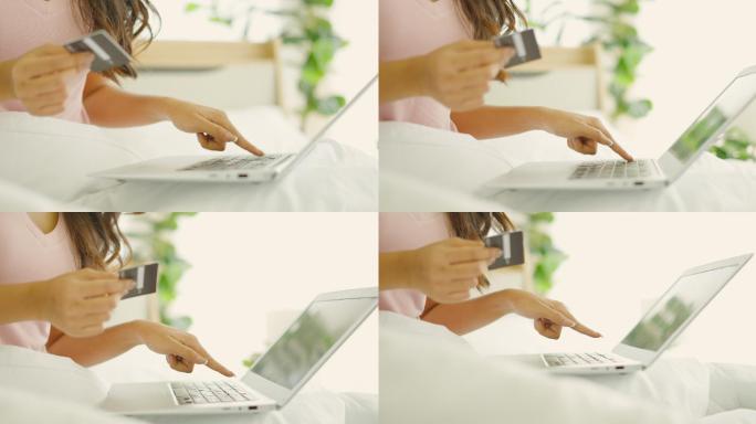 女性在家中的笔记本电脑上输入银行信用卡信息、在线购买商品或服务或在网店付款。电子商务理念，舒适生活。