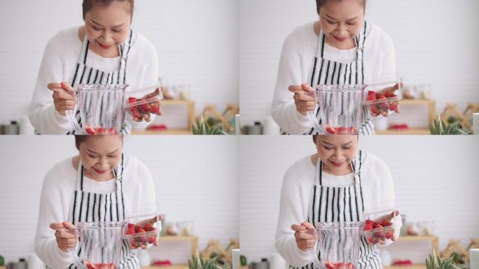 一位亚洲资深女性，教她如何用不同的调味品、草莓和酸奶制作自制水果冰沙。健康天然益生菌口味饮料，正面视