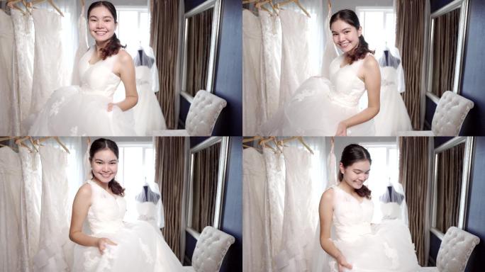 新娘微笑着，喜欢在婚礼工作室试穿新娘礼服。