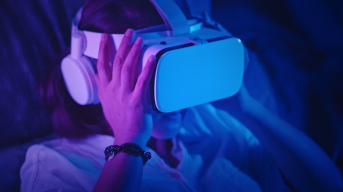 女性戴上虚拟现实耳机，在虚拟现实世界中享受乐趣