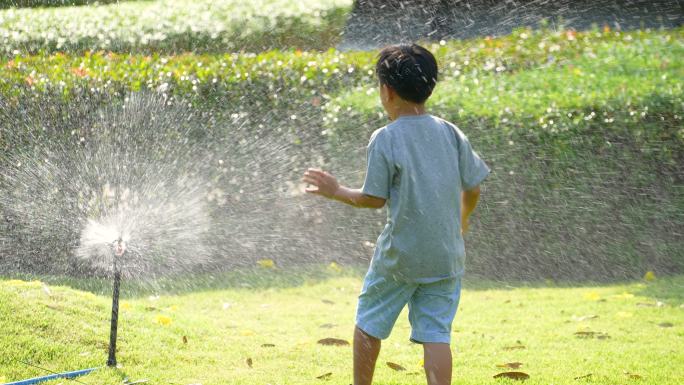 亚洲小孩在公园里玩泼水游戏。夏天和幸福的概念
