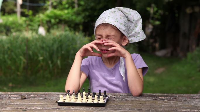 小女孩把棋子摆在棋盘上，等待比赛开始