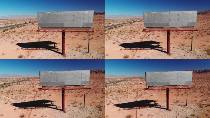 在犹他州沙漠15号州际公路旁，在晴朗的蓝天下，无人机拍摄了一个空白的废弃广告牌广告