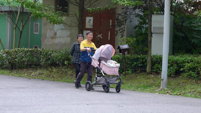 爷爷奶奶推着婴儿车走出小区