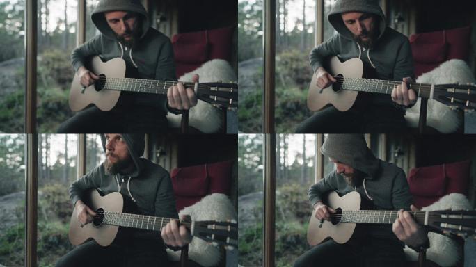 在偏远小屋的孤独中弹奏原声吉他的人