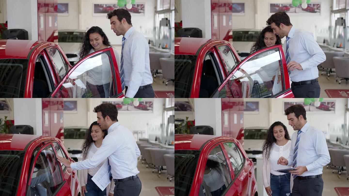 经销商处的拉丁美洲销售员向女性客户展示了一辆车，并愉快地解释了一切