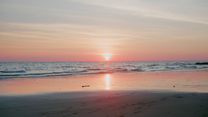 日落时反射阳光的海滩
