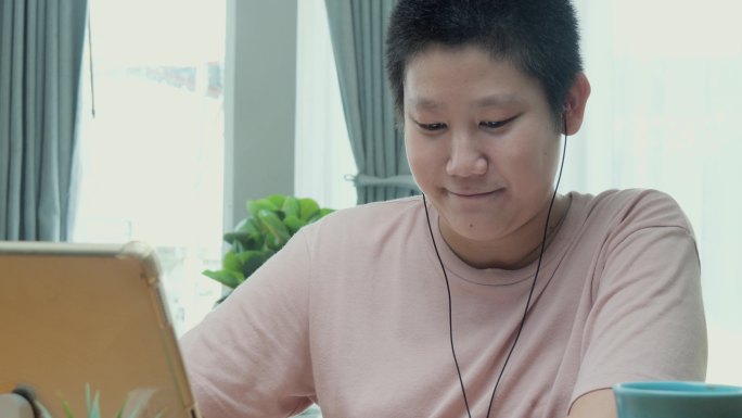 2019冠状病毒疾病期间，亚洲学童在家里餐桌上通过数字平板电脑学习在线课程，隔离和社交疏远生活方式概
