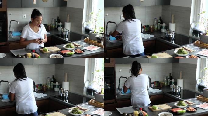 在她开始做寿司之前，负责的女人，清洗鳄梨和准备新鲜食材