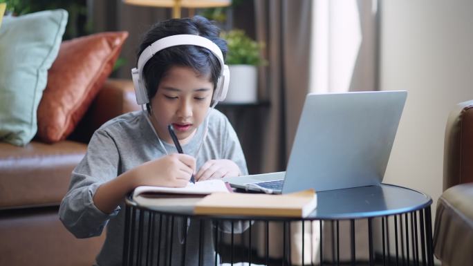 亚洲青少年在起居室通过数字远程设备笔记本电脑网络会议从学校老师那里学习电子学习在线课程，亚洲青少年在